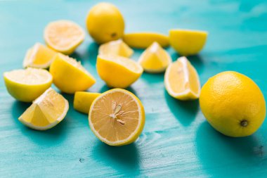 Turkuaz ahşap masada taze limon yığını.