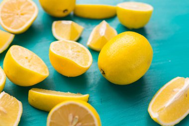 Taze kesilmiş yarım limon ve tüm limonlar kırsal akuamarin renk tahtalarında. Yaz, vitaminler ve tazelik konsepti.
