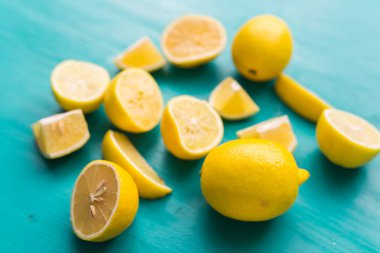 Turkuaz ahşap masada taze limon yığını.
