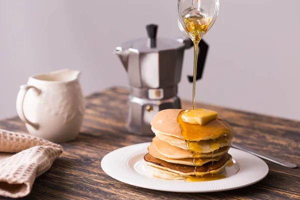 Nahaufnahme des Gießens von Ahornsirup auf einen Stapel Pfannkuchen. — Stockfoto