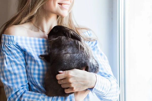 Концепция домашних животных и Пасхи - девочка обнимает коричневого кролика дома, крупным планом . — стоковое фото