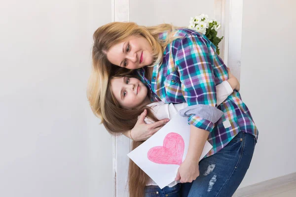 Día de las Madres, fiestas y fiestas familiares - Madre sostiene la tarjeta de felicitación de su encantadora hija . —  Fotos de Stock