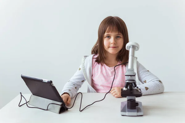 Retrato de un niño haciendo los deberes con un microscopio digital. Concepto de tecnologías, ciencia y niños . —  Fotos de Stock