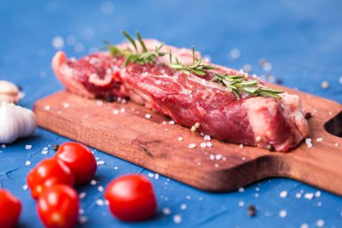 Ahşap arka planda baharatlı ve otlu biftek fileto.