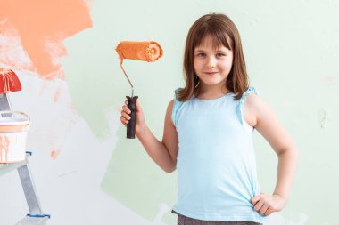 Tadilat duvarını boyayan küçük bir çocuk. Dekorasyon, onarım ve yeniden boyama kavramı.