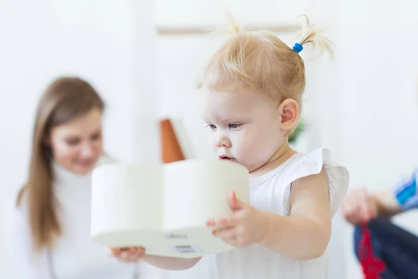 Lustig liten flicka som leker i vardagsrummet. Barn- och familjebegreppet. — Stockfoto