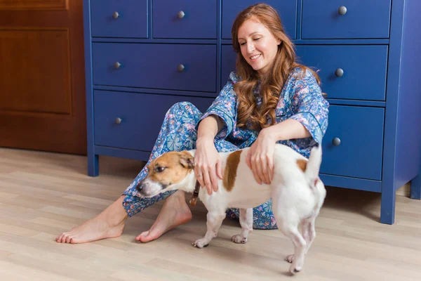 快乐的年轻女人和她的狗一起坐在家里。宠物的主人、动物和友谊的概念. — 图库照片