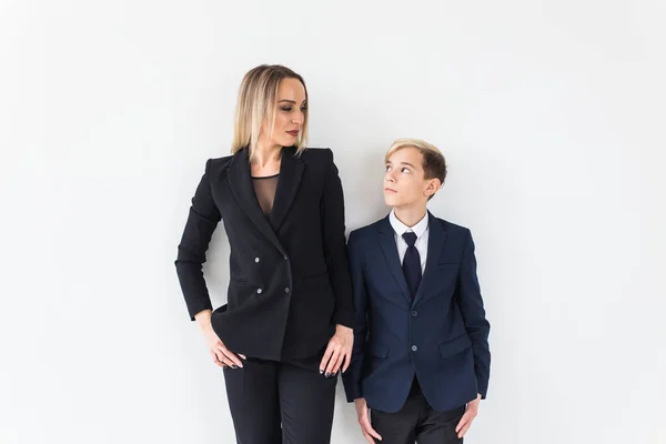Teenager a svobodný rodič - Mladá matka a syn stojící společně na bílém pozadí. — Stock fotografie