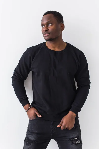 Youth street fashion concept - Portrait of confident sexy black man in stylish sweatshirt on white background. — Stock Photo, Image