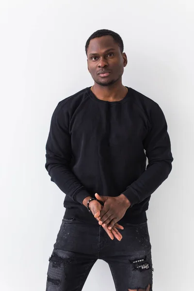 Handsome African American man posing in black sweatshirt on a white background. Youth street fashion photo with afro hairstyle. — Stock Photo, Image