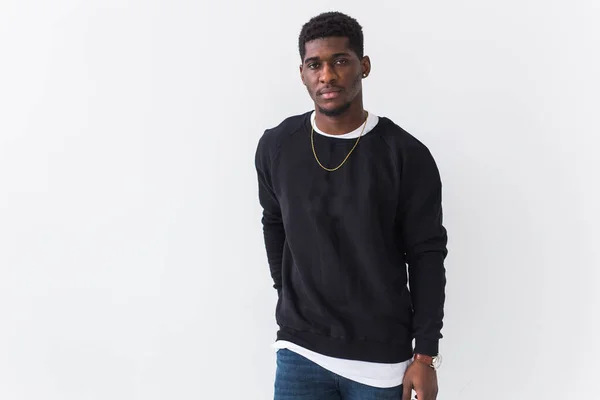 Portret van knappe jonge zwarte man gekleed in jeans en sweatshirt op witte achtergrond met copyspace. Straatmode en moderne jeugdcultuur. — Stockfoto