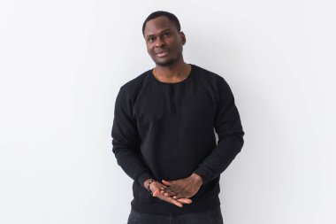 Afro saçlı, yakışıklı Afrikalı Amerikalı bir adam. Beyaz arkaplanda fotokopi alanı olan bir portre. Kameraya bakan adam..