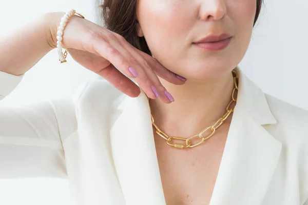 Närbild av kvinna bär ett guld halsband och armband. Smycken, bijouterie och tillbehör koncept. — Stockfoto