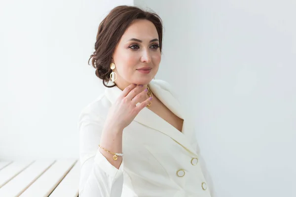 Sparatoria di alta moda di giovane donna bruna con acconciatura elegante in abito bianco all'interno. Uomini d'affari e concetto di stile alla moda . — Foto Stock