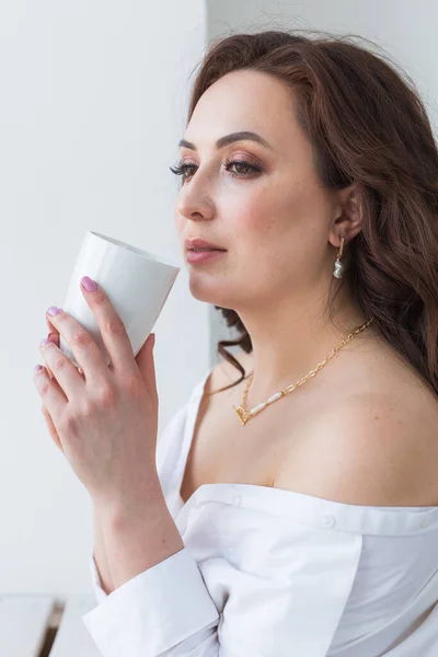 Close up de belas mãos femininas segurando grande xícara branca de café cappuccino . — Fotografia de Stock