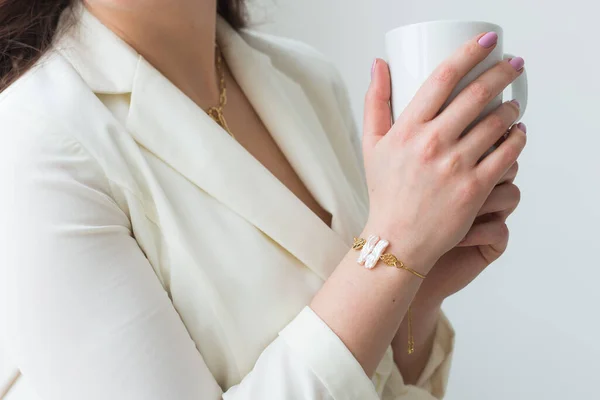 Kvinnors hand håller en vit kopp kaffe. Med en vacker manikyr närbild. Drick, mode, morgon — Stockfoto