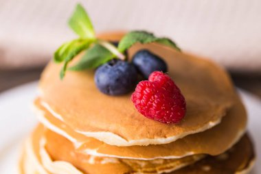 Ahşap arka planda yabanmersinli krep ve ahududu. Kahvaltı ve geleneksel yemek..