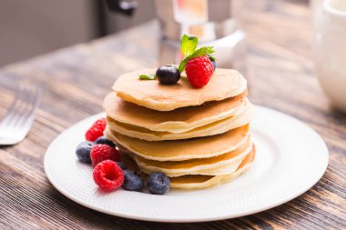 Ahşap arka planda yabanmersinli krep ve ahududu. Kahvaltı ve geleneksel yemek..