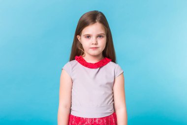Mavi arka planda izole edilmiş güzel küçük bir kız. Çocukluk ve çocuk kavramı.