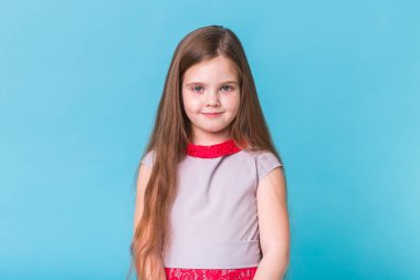 Mavi arka planda izole edilmiş güzel küçük bir kız. Çocukluk ve çocuk kavramı.