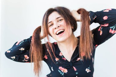 Neşeli ve neşeli komik kızıl saçlı kadın beyaz arka planda gülüyor..