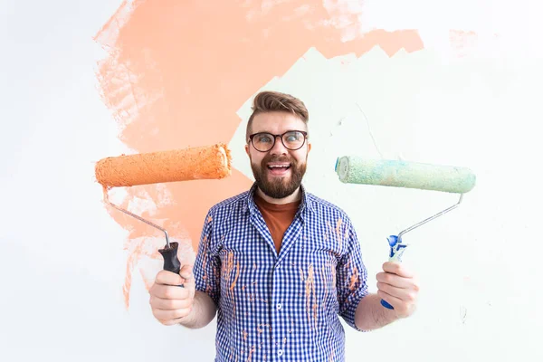 Repair in the apartment. Funny man paints the wall with paint. — Stock Photo, Image