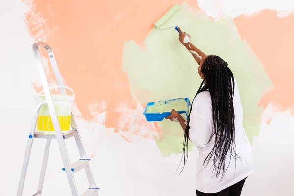 Mutlu gülümseyen Afrikalı Amerikalı kadın yeni evin iç duvarını boyuyor. Dekorasyon, yenileme, apartman onarımı ve ferahlatıcı konsept. — Stok fotoğraf