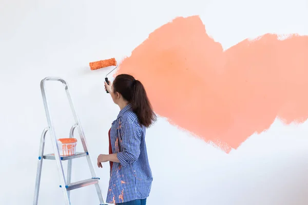 Ristrutturazione, ridecorazione e concetto di riparazione Allegro muro di pittura donna in una nuova casa. Copia spazio . — Foto Stock
