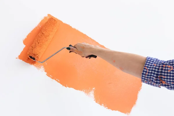 Primo piano pittura a mano parete interna con rullo di vernice nella nuova casa. Una donna con rullo che applica vernice su un muro . — Foto Stock