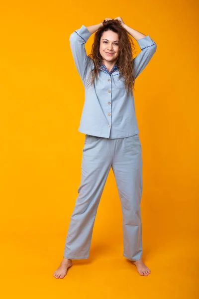 Niña posando en pijama sobre fondo amarillo. Relaja el buen humor, el estilo de vida y el concepto de ropa de dormir . — Foto de Stock