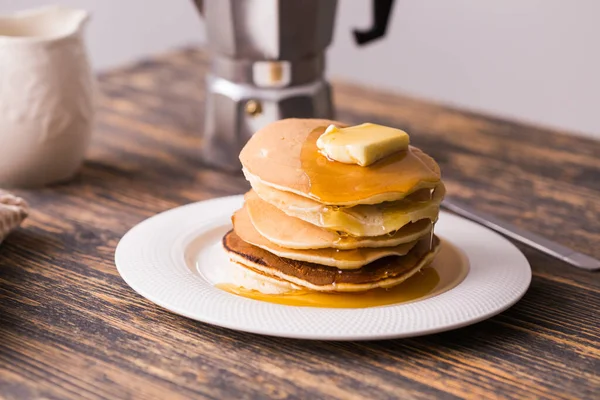 Kleine pannenkoeken met ahornsiroop en boter op houten tafel. Ontbijt concept. — Stockfoto