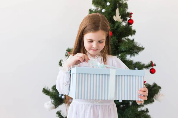 Feiertage, Geschenke, Weihnachten, Weihnachtskonzept - glückliches Kind öffnet Geschenkbox. — Stockfoto