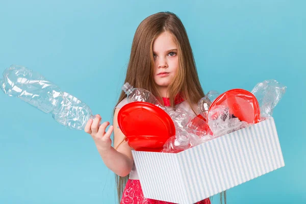 Protección del medio ambiente y concepto de contaminación. Caja de transporte infantil sorprendida con basura plástica sobre fondo azul . —  Fotos de Stock