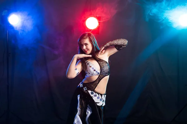 Young woman dancing in Tribal Fusion style. Belly dance on the stage.