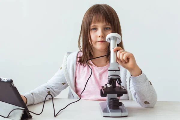 Colegiala usando microscopio en clase de ciencias. Tecnologías, lecciones y concepto infantil . —  Fotos de Stock