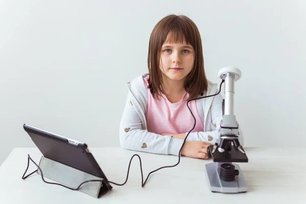 Retrato de un niño haciendo los deberes con un microscopio digital. Concepto de tecnologías, ciencia y niños . —  Fotos de Stock