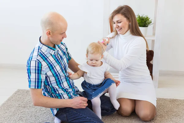Glückliche Familie, Mutter, Vater und ihr Baby zusammen im heimischen Wohnzimmer. Kinder- und Kleinkindkonzept. — Stockfoto