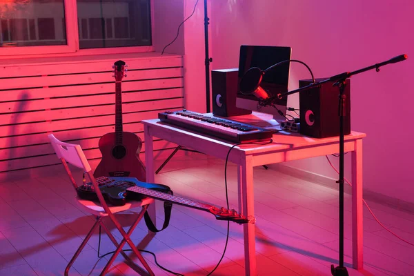 Mikrofon, Computer und Musikinstrumente Gitarren und Klavierhintergrund. Konzept für Heimaufnahmestudios. — Stockfoto