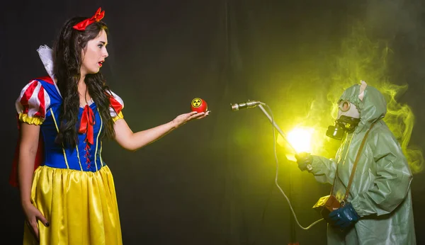 Femme habillée en personnage de conte de fées détient Radioactive nucléaire ionisant rayonnement nucléaire danger symbole d'avertissement sur la pomme. Concept de mesure nucléaire et radiologique . — Photo