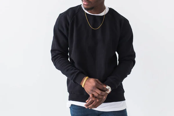 Close-up of black man dressed in jeans and sweatshirt on white background. Street fashion and modern youth culture. — Stock Photo, Image