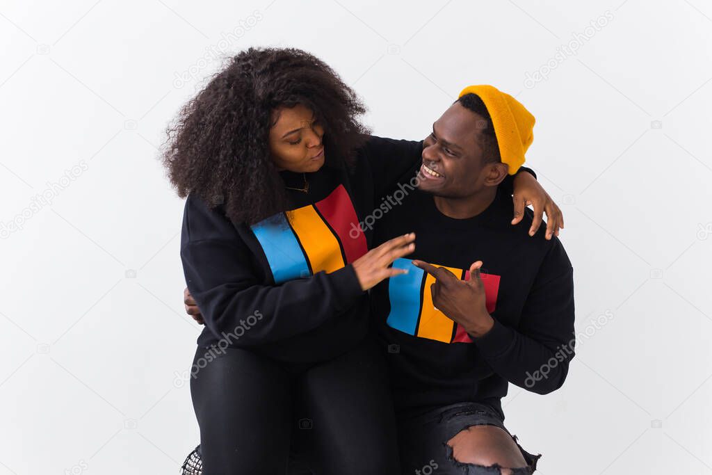 Happy African American woman and man have relationships, toothy smile, happy to meet with friends, dressed casually on white background. Emotions and friendship concept.