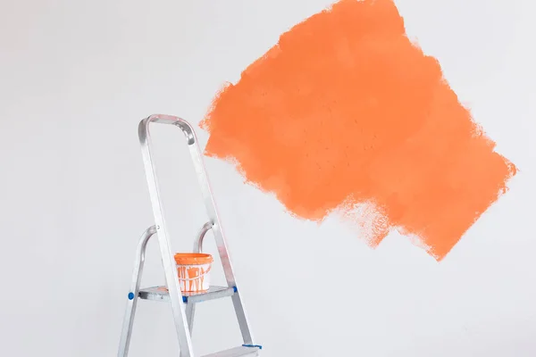 Ladder with paint in bucket near color wall indoors. Renovation and redecoration concept. Copy space. — Stock Photo, Image