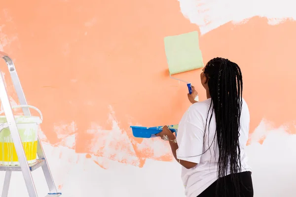 Apartmanda tamirat var. Mutlu genç bir kadın duvarı boyuyor.. — Stok fotoğraf