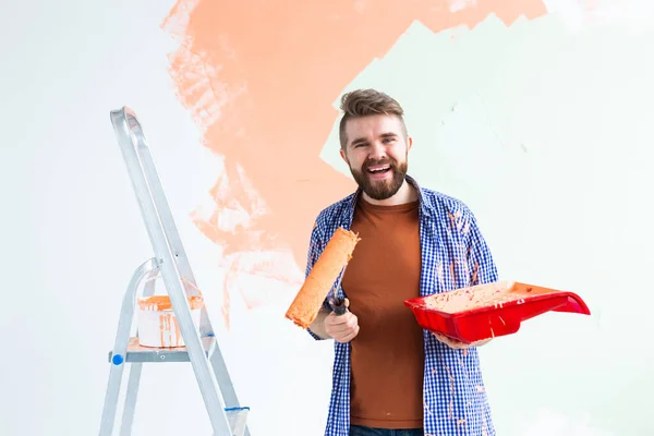 Man painting wall in her new apartment. Renovation and redecoration concept. — Stock Photo, Image