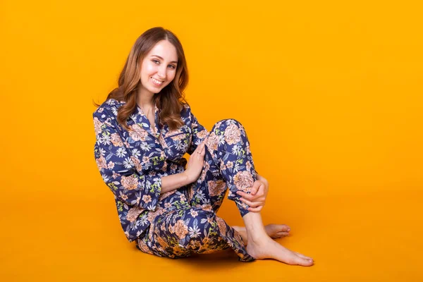 Nette und fröhliche Frau Studio Lifestyle gelb Hintergrund Emotionen. Pyjama- und Heimbekleidungskonzept. — Stockfoto