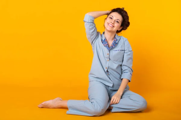 Niña posando en pijama sobre fondo amarillo. Relaja el buen humor, el estilo de vida y el concepto de ropa de dormir . — Foto de Stock