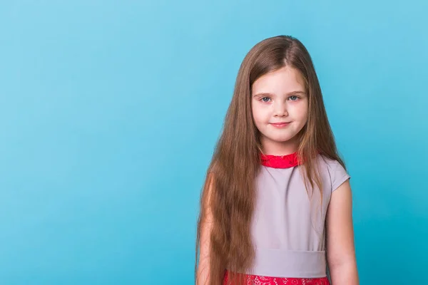 Vacker liten flicka isolerad på en blå bakgrund med kopieringsutrymme. Begreppet barndom och barn. — Stockfoto