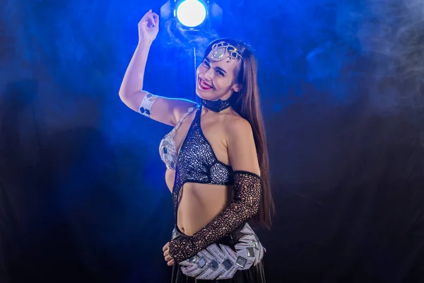 Young woman belly dancer in exotic dress with gold, dancing tribal fusion dance in studio. — Stock Photo, Image