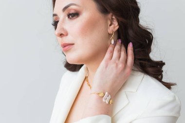 Küpeli zarif bir kadın, yakın portre. Aksesuarlar, mücevherler ve bijouterie konsepti.