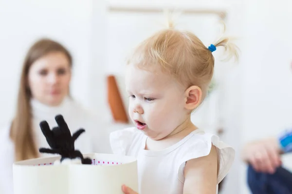 Lustig liten flicka som leker i vardagsrummet. Barn- och familjebegreppet. — Stockfoto